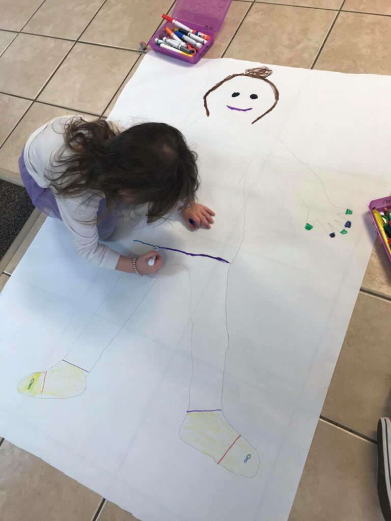 child drawing with markers on paper